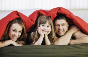 family relaxing in bed
