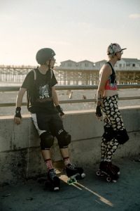 Young man and woman wearing roller skating safety gear